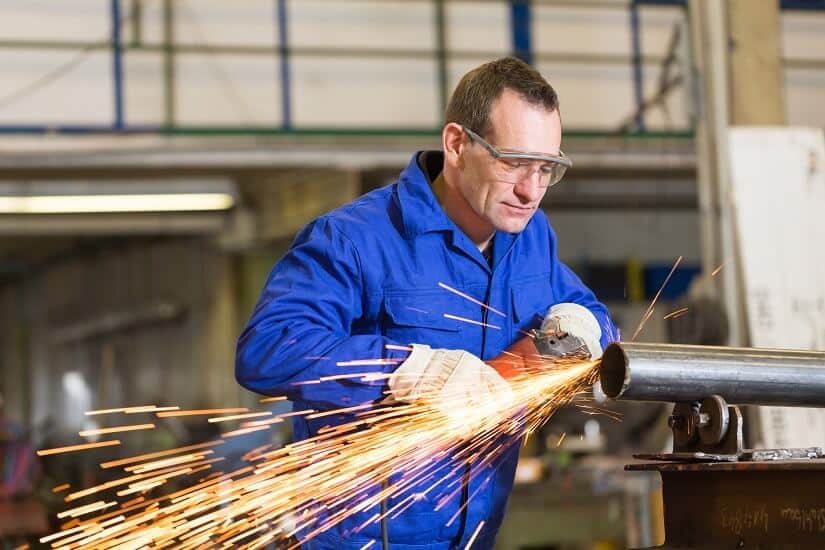 Stahlbauarbeiter schleift Metall mit einem Einhand Winkelschleifer