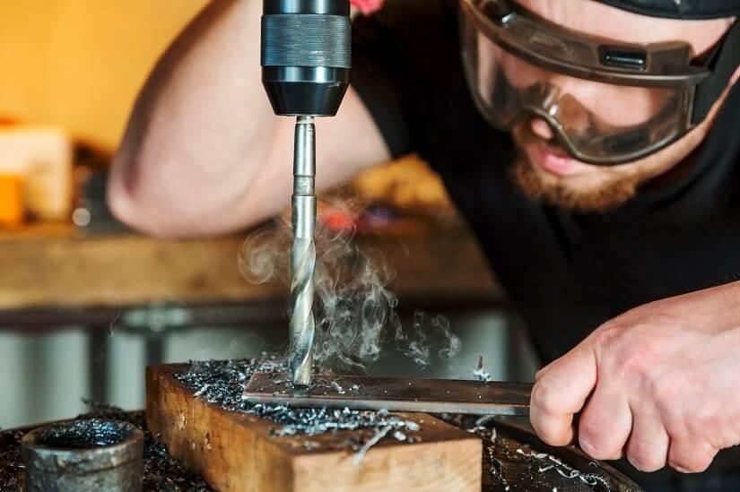 Arbeiter mit einem scharfen Metallbohrer