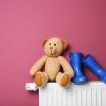 Heizkörper mit Teddy Bär und Gummi-Stiefeln darauf